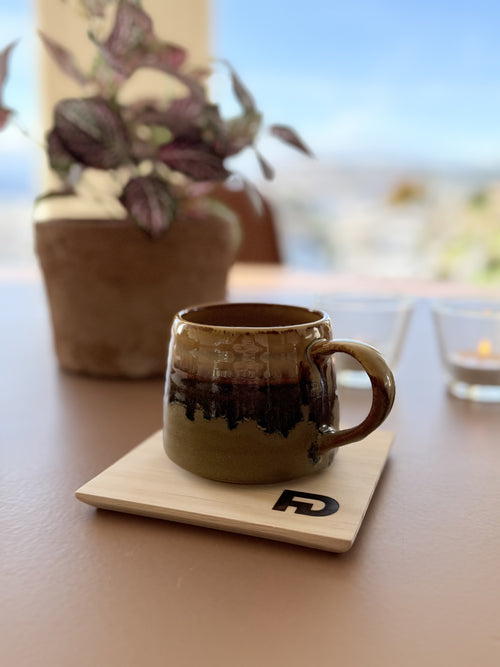 Bordbeskytter i tre under kaffekopp